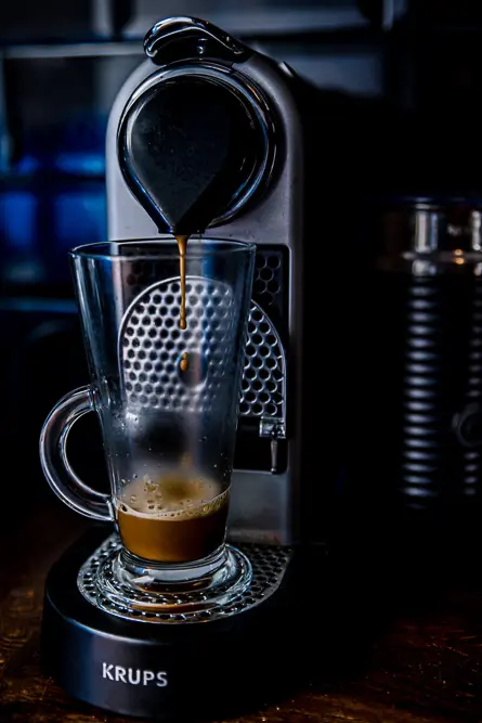 Coffee machine brewing a coffee into coffee glass