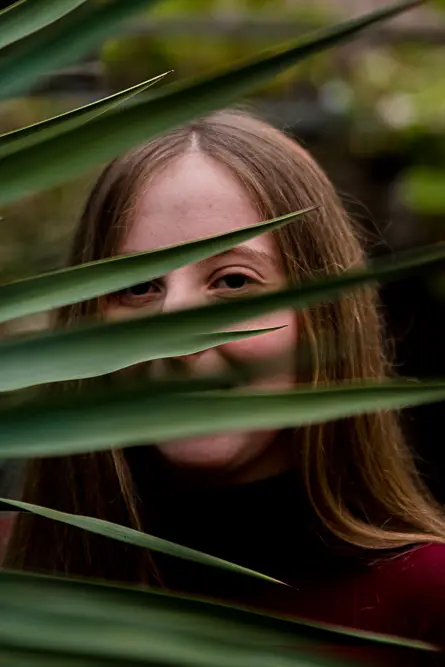 Outdoor Personal Brand Portrait of young woman through leaves