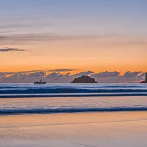 Boat silhouette from beach at sunset
