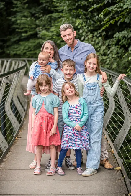 Outdoor Family Portrait of young family of 7 on bridge