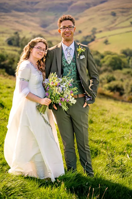 Bride holding groom's arm at Cronkshaw Fold Farm, Rossendale
