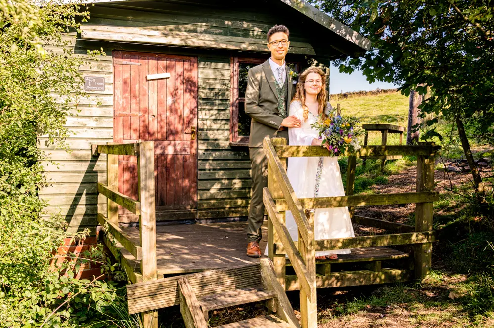 Bride and groom by the little cabin at Cronkshaw Fold Farm, Rossendale
