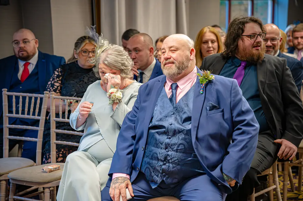 Wedding guests. Mother of the groom wiping her eye.