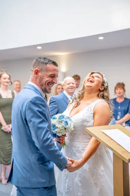 The bride and groom holding hands while laughing