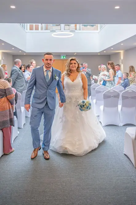Bride and groom walking up the aisle together after the ceremony, Bury registry office