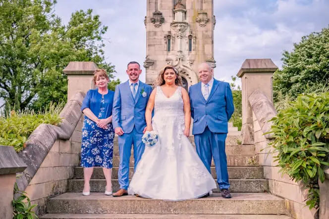 Bride and groom with the bride's parents on the steps at The Whitehead Clock Tower, Bury