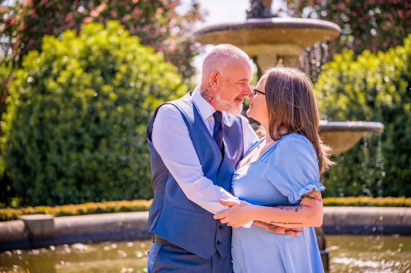 Paul and Sarah's Engagement Shoot at Alexandra Park, Oldham Close up of a couple with noses touching, water fountain behind them, taken by Oldham Photographer Wedding Rebekah Morecroft
