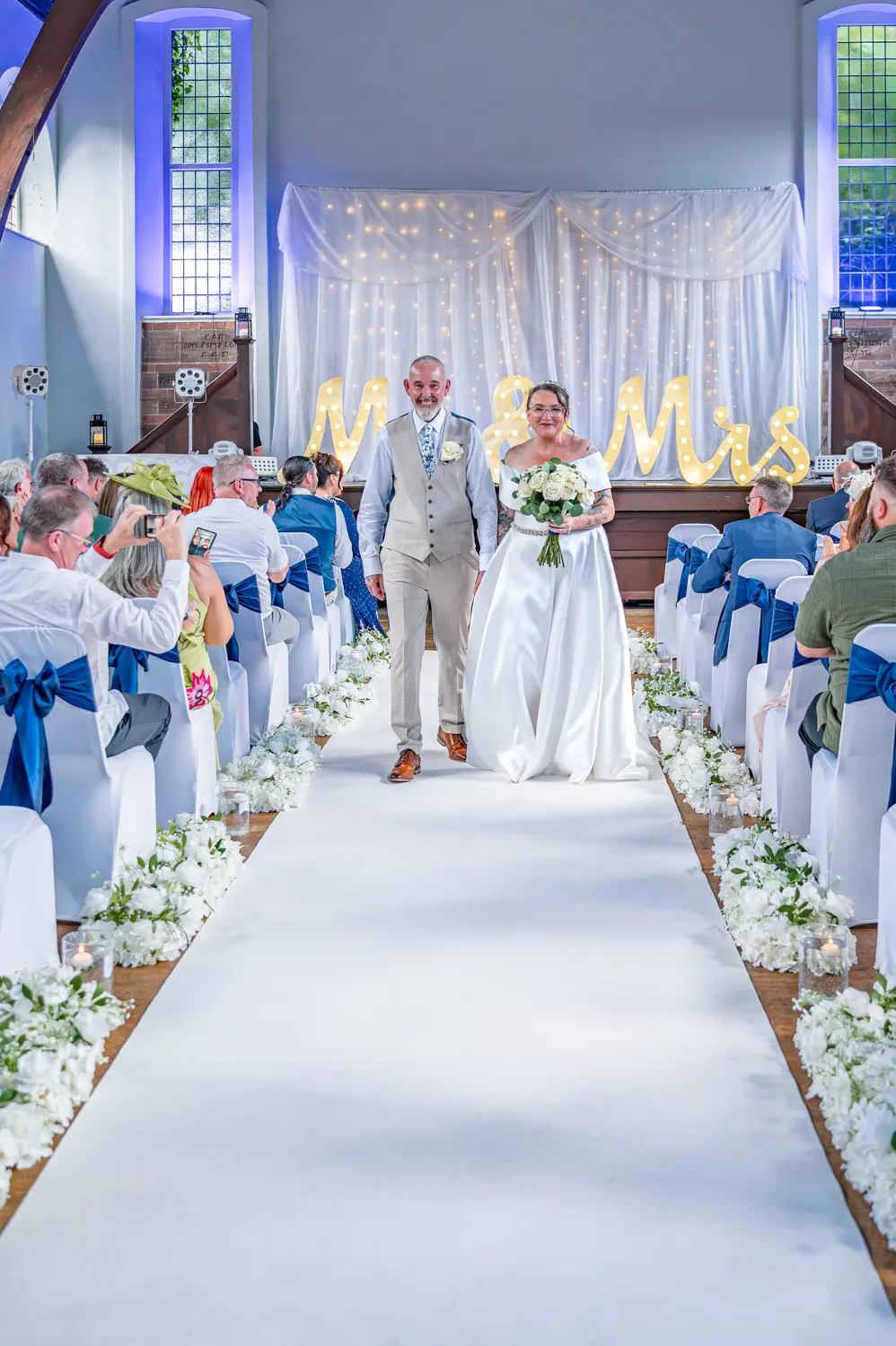 The bride and groom smiling and walking back down the aisle together as husband and wife
