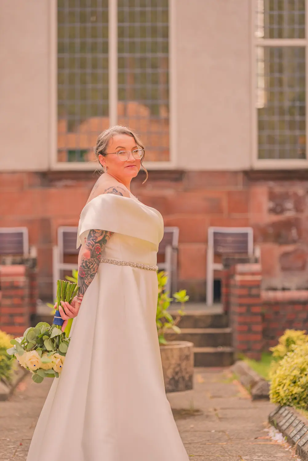 A elegant side profile portrait of the bride holding her colorful summer bouquet