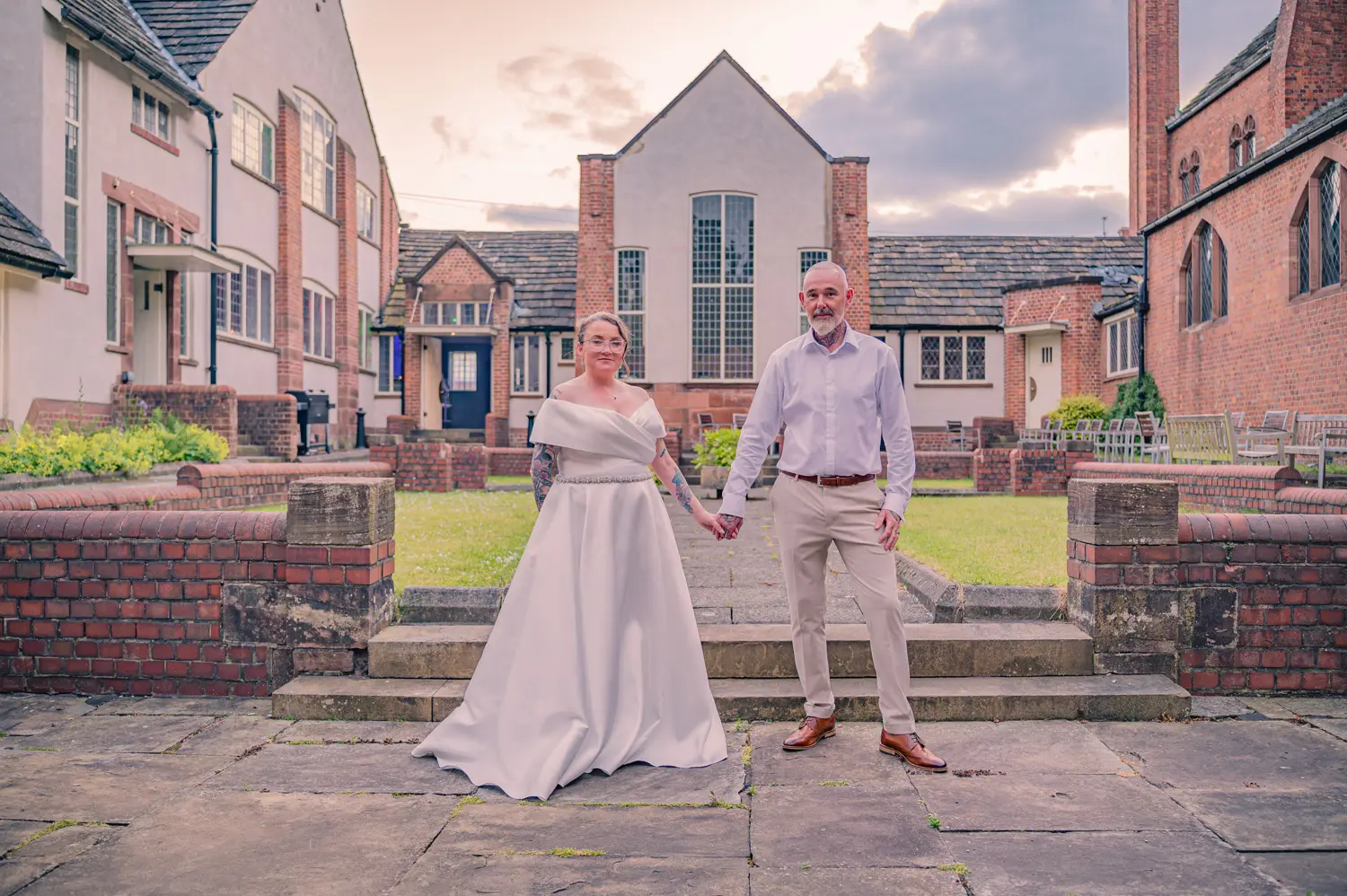 Golden hour portrait of the bride and groom with the historic venue in the background, beautifully taken by an Old School Rooms wedding photographer