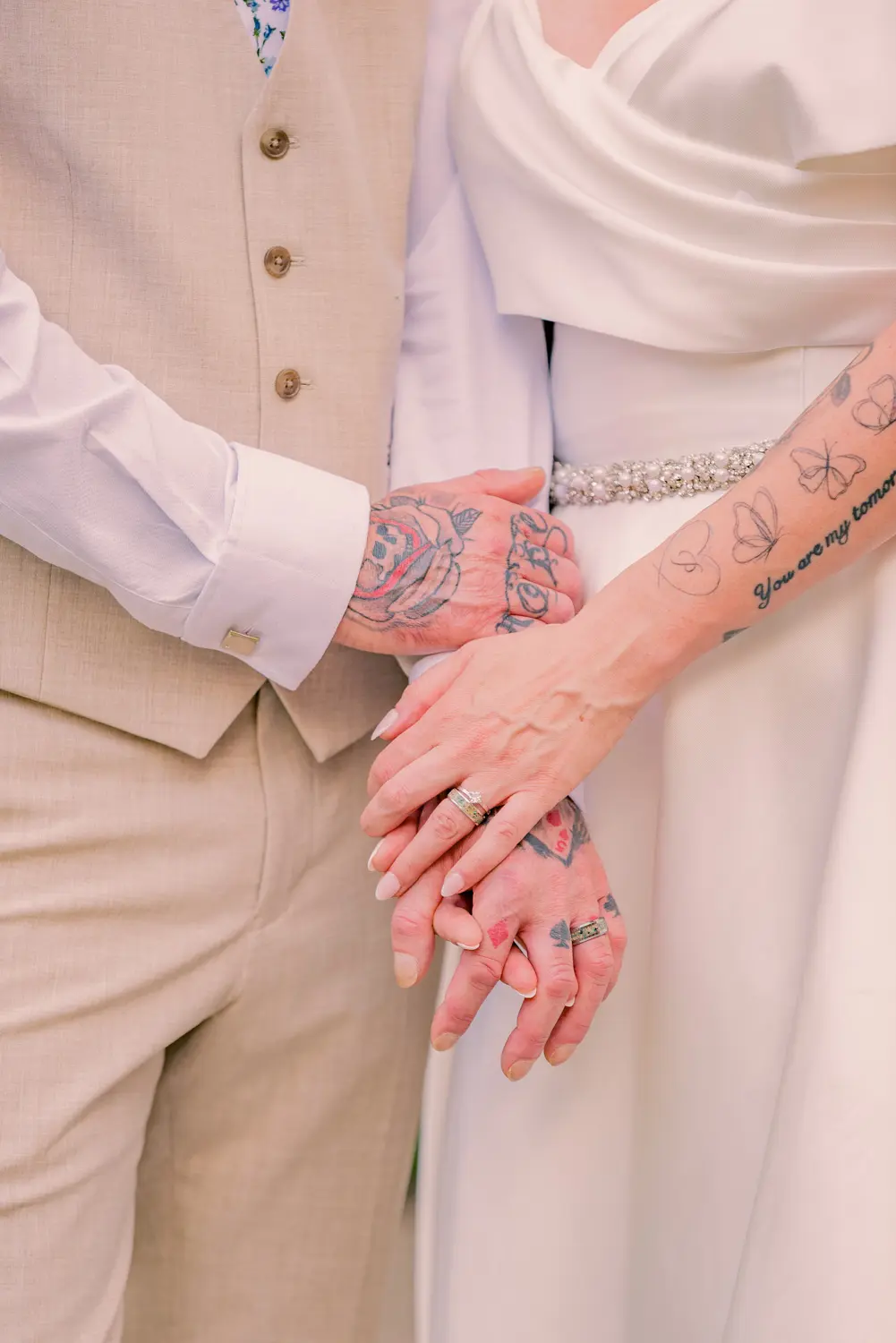 A further close-up photograph focusing on the couple's interwoven hands and fingers.