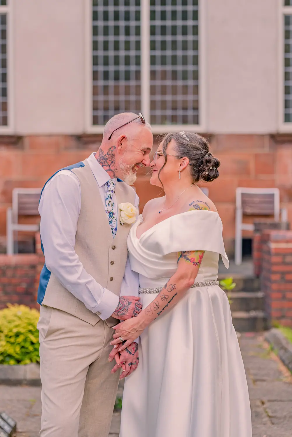 Joyful portrait of the bride and groom sharing a genuine laugh together outside