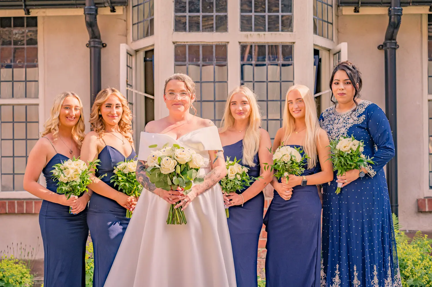 Portrait of the bride and her bridal party wearing deep blue dresses