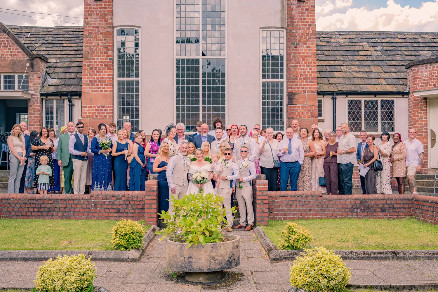 Whole wedding guests group photograph taken on the stone steps