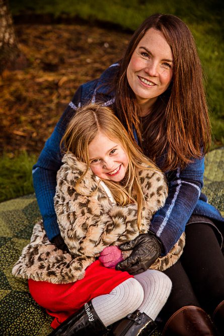 Outdoor Family Portrait of mother and daughter cuddling on a blanket