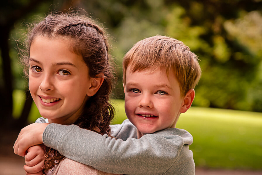 Outdoor Family Portrait of young boy piggybacked on girls back