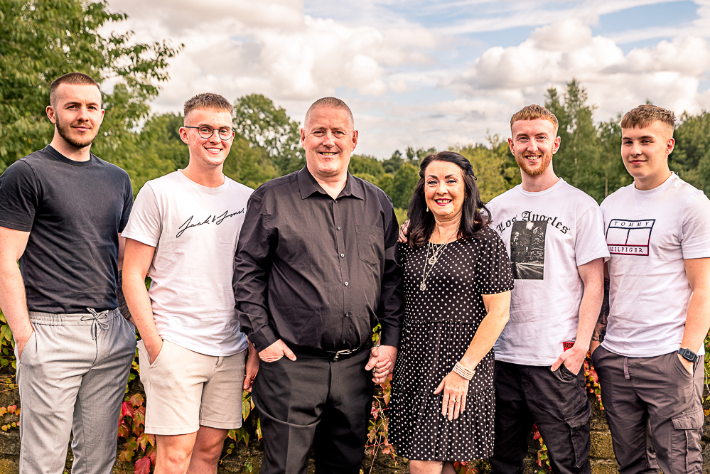Family photography of a family of 6 including 4 young adult men outdoors.