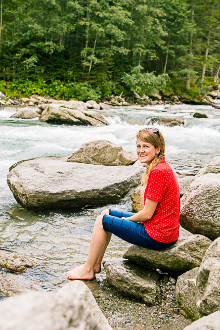 Outdoor Personal Brand Portrait of young woman sitting by a river with jeans rolled up and toes in the water