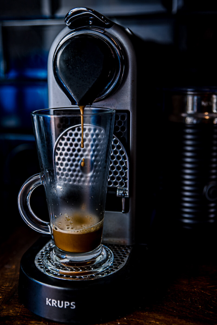 Coffee machine brewing a coffee into coffee glass