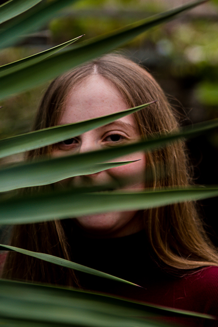 Outdoor Personal Brand Portrait of young woman through leaves
