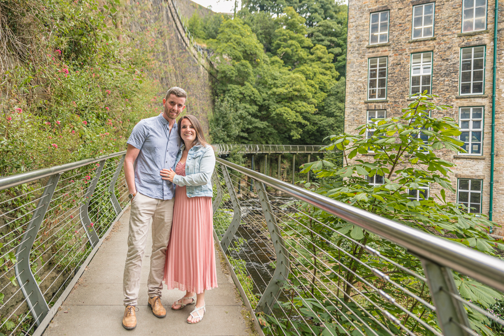 Outdoor Family Portrait of couple cuddling on bridge