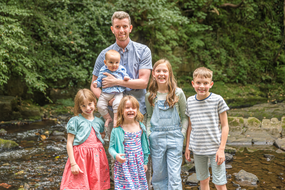 Outdoor Family Portrait of dad with five kids and holding the baby.