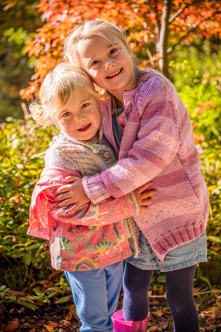 Outdoor Family Portrait of 2 young sitters cuddling