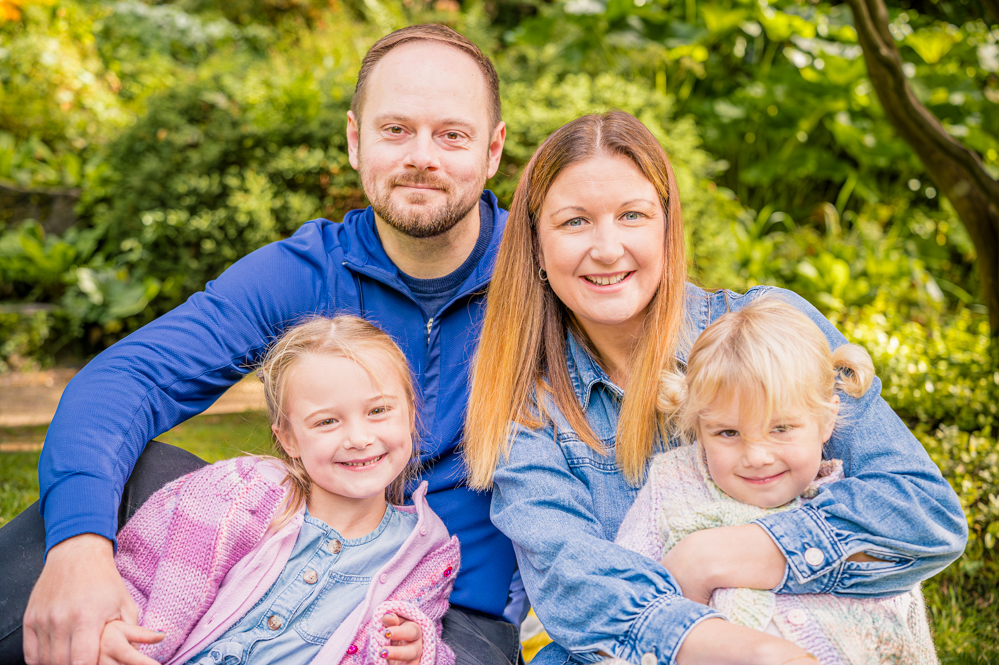 Family of four sitting outdoors, natural family photography Didsbury, Manchester