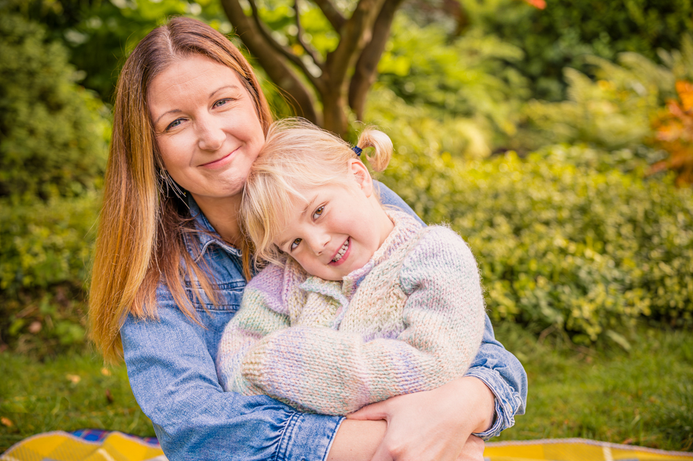 Outdoor Family Portrait of mother and young daughter cuddling