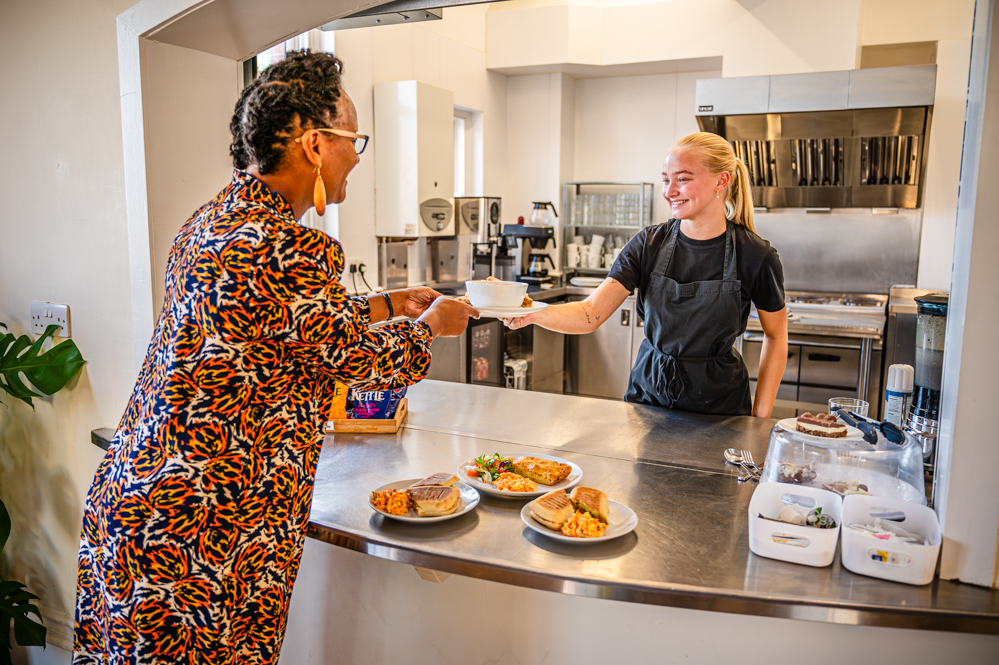 Women serving food to female customer