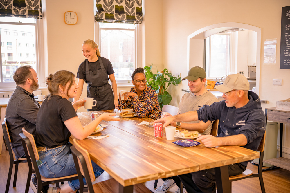 Group of people enjoying lunch together while one is being served food