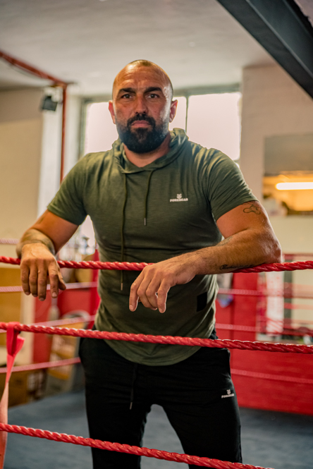 Personal Branding Photography of Man leaning against boxing ring.