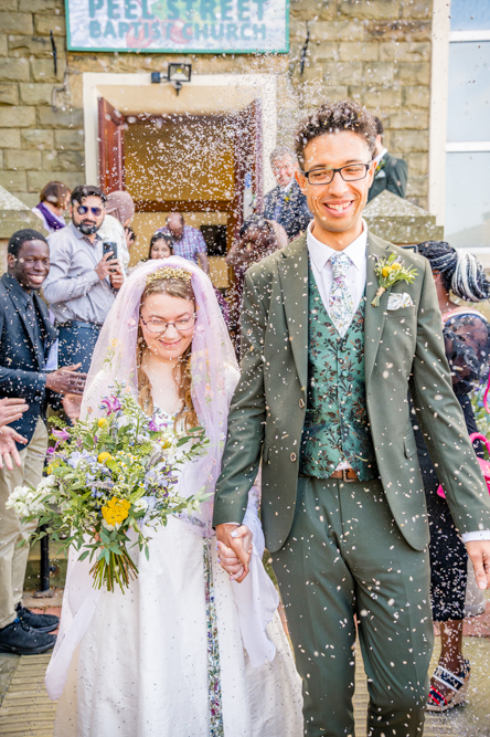 Bride and groom with confetti being thrown over them outside Peel Street Baptist Church, Accrington