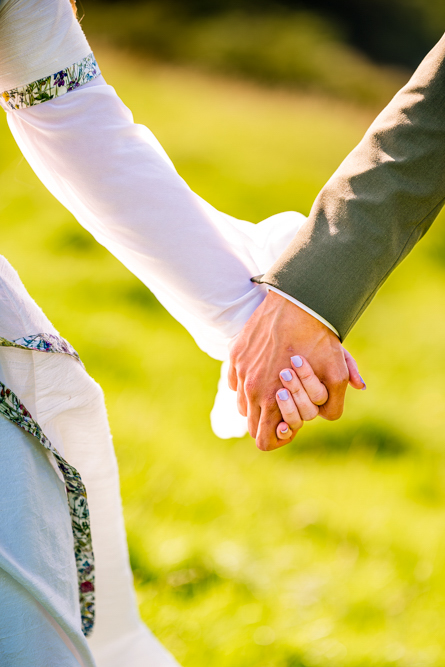 Close up of bride and groom holding hands during their couple portraits at Cronkshaw Fold Farm, Rossendale