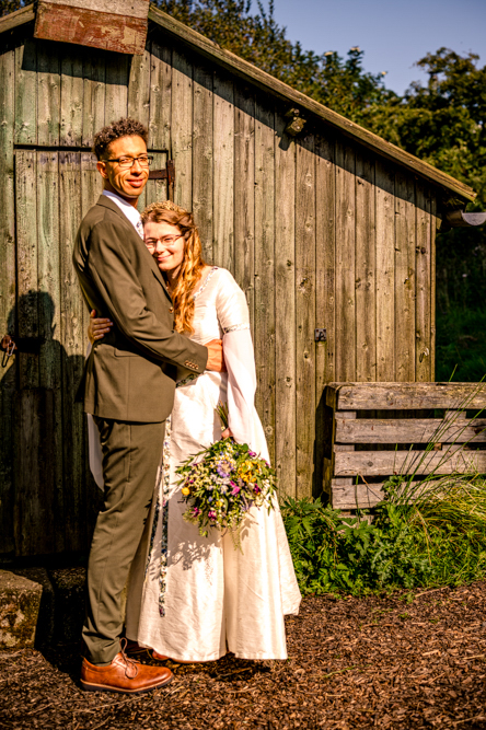 Bride and groom standing outside the barn at Cronkshaw Fold Farm, Rossendale