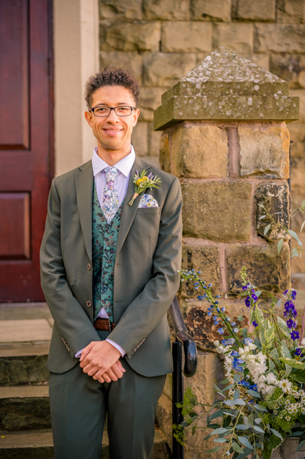 Groom standing by the steps at Peel Street Baptist Church, Accrington, before his summer wedding