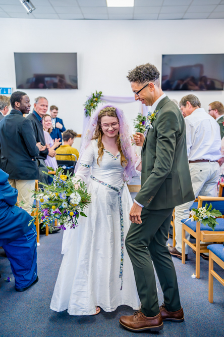 Natural Wedding Photos – The Recessional Just married couple walking down the aisle celebrating during their wedding recessional moment