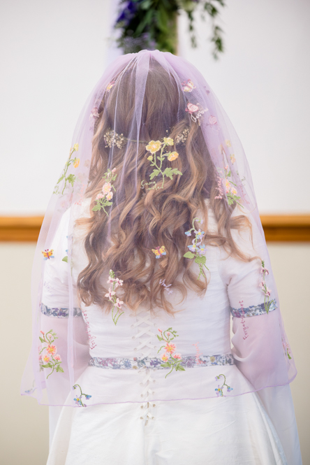 The back of the bride showing her beautiful purple veil during her wedding ceremony at Peel Street Baptist Church