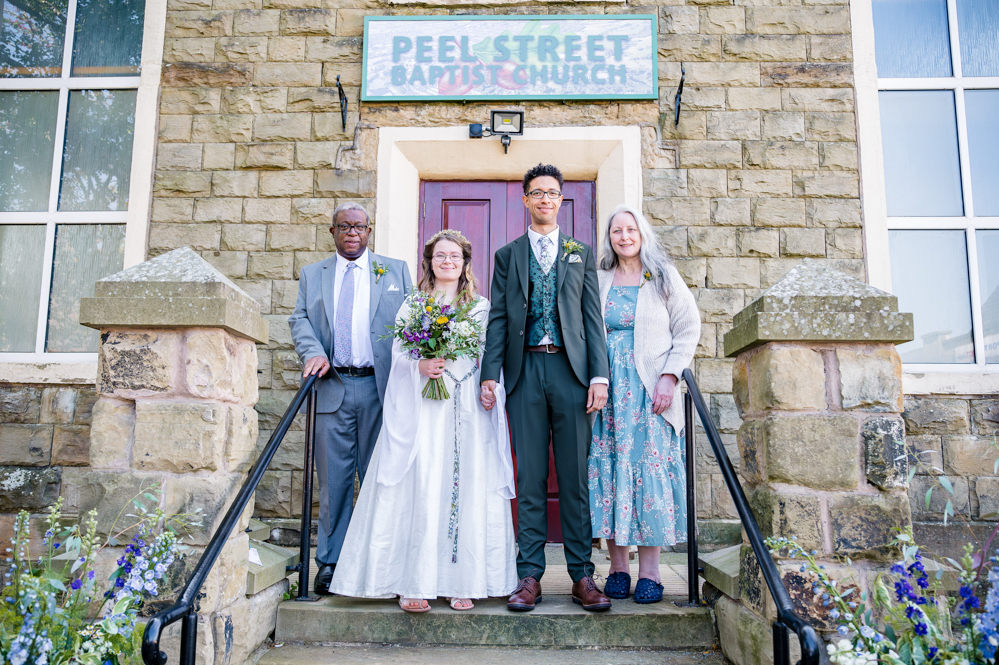 Bride and groom with the groom's parents outside Peel Street Baptist Church, Accrington