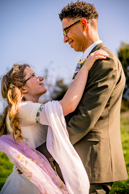Bride and groom looking into each other's eyes in a field at Cronkshaw Fold Farm, Rossendale