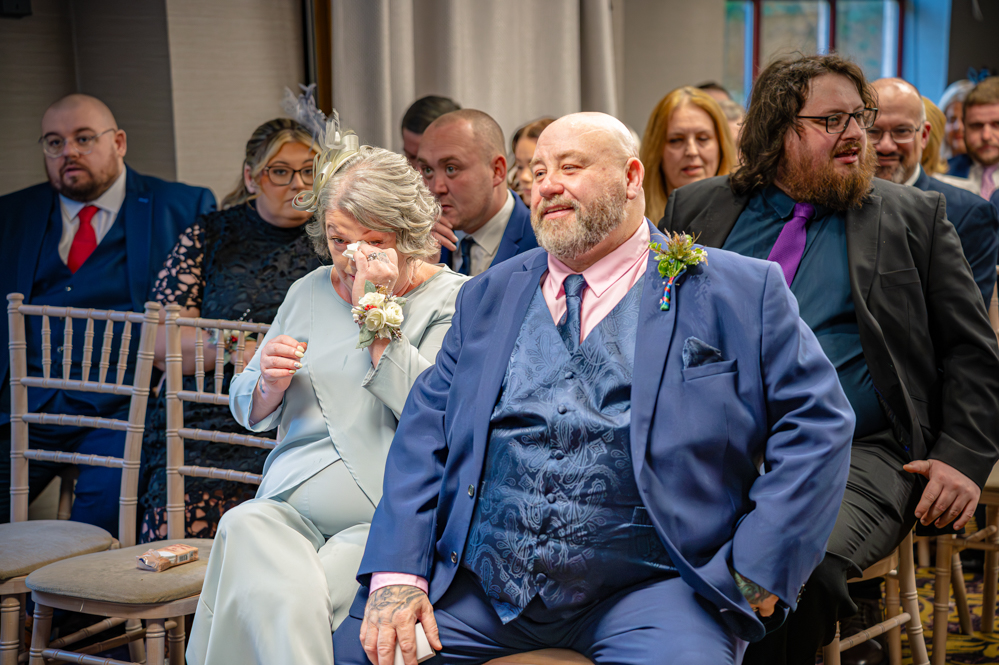 Wedding guests. Mother of the groom wiping her eye.