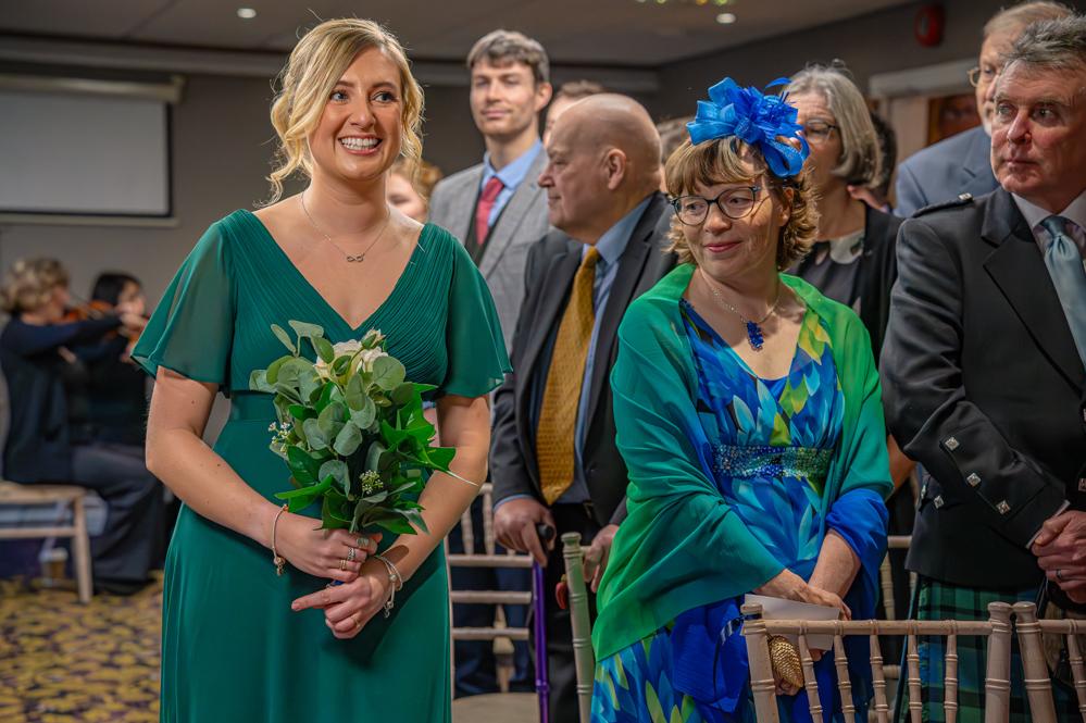 Bridesmaid walking down the isle in a green dress