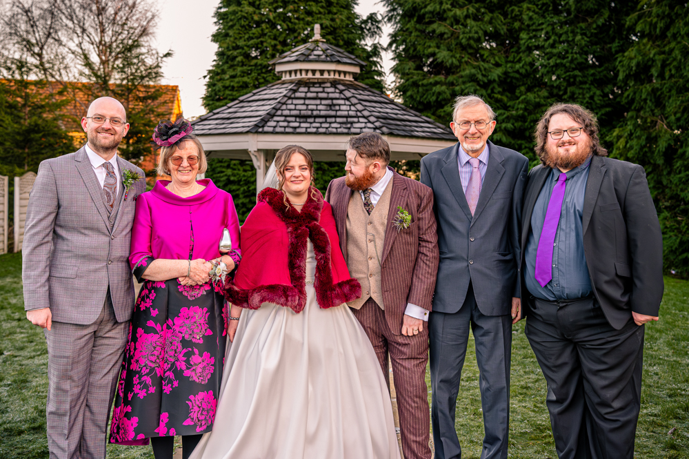 Bride and Groom with Mother of the Bride, Step Father and Two Brothers with bandstand behind them