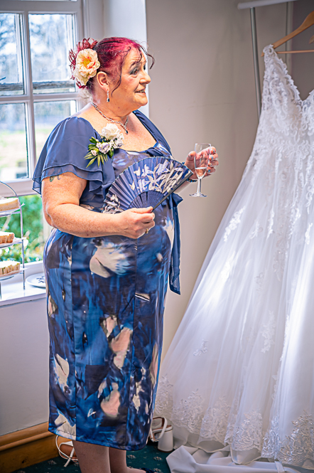 Mother of Bride holding a fan and glass of wine