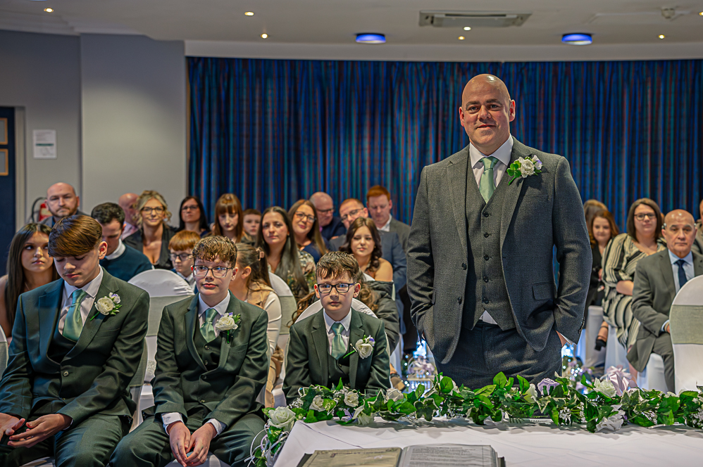Groom standing while guests are seated while waiting for the bride to enter