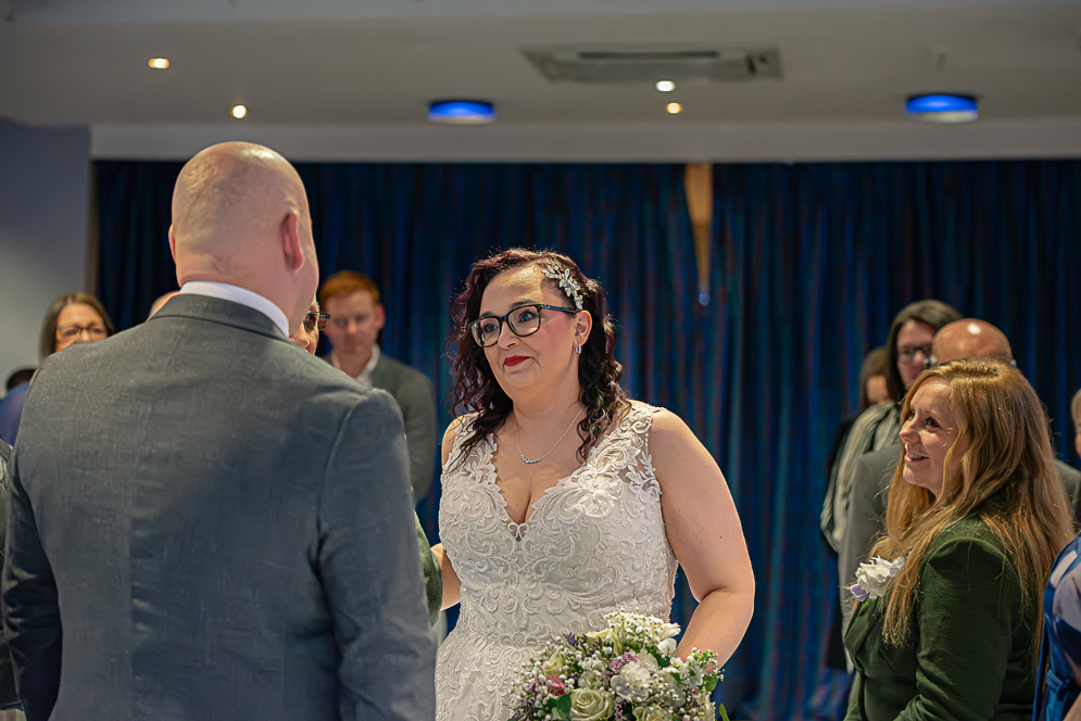 bride looking at groom as she reaches the top of the aisle.