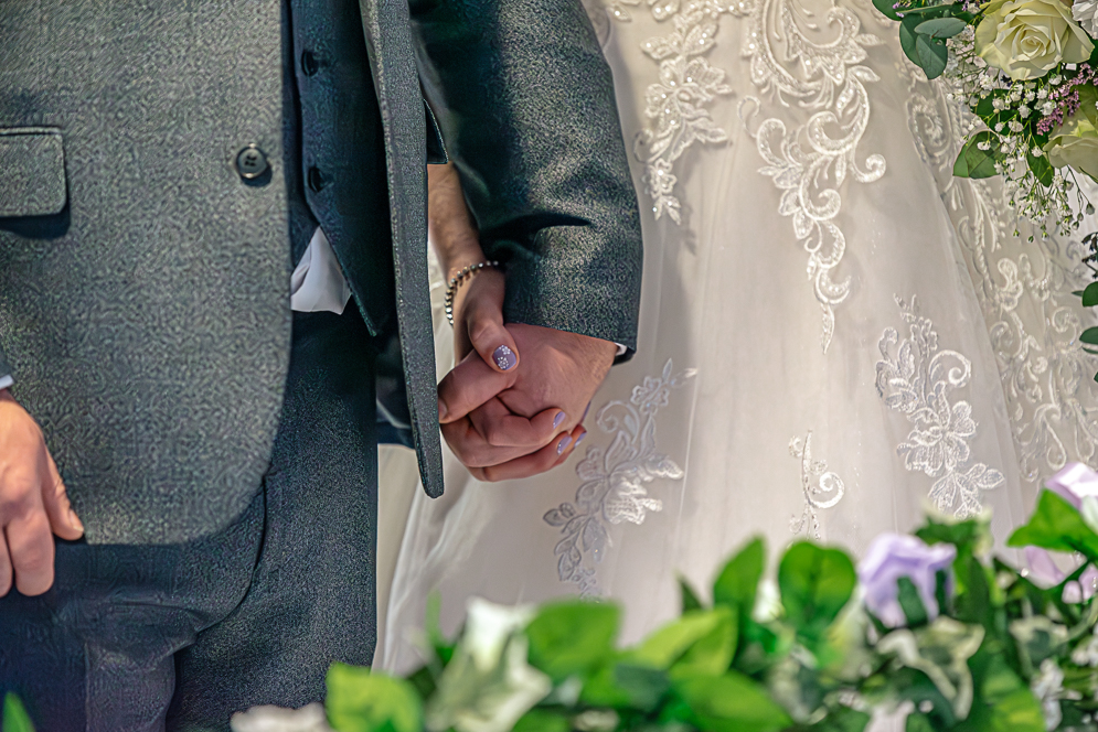 Close up of bread and groom holding hands
