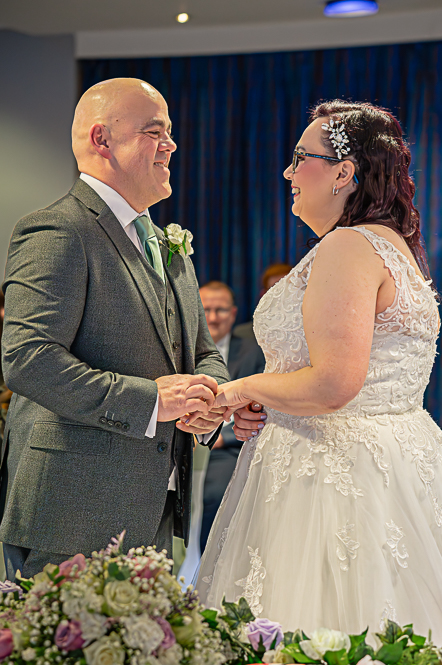 groom putting the ring on brides hand.