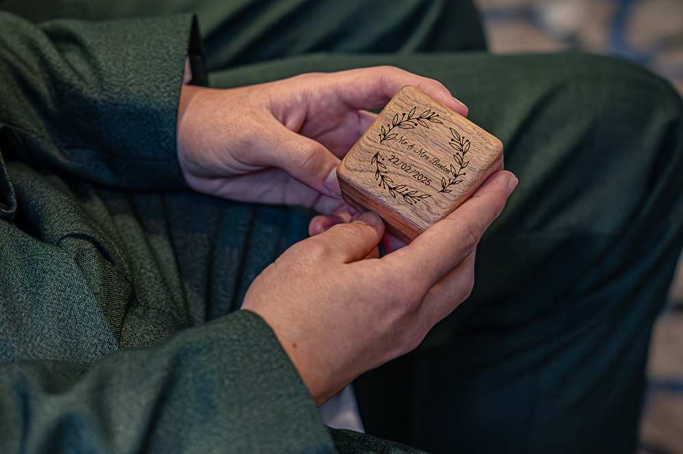 Close up of Groomsman holding wooden wedding ring box