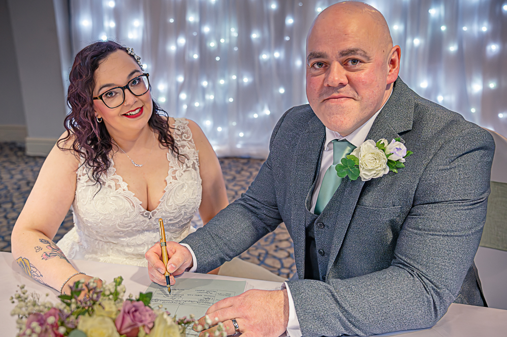Groom signing the register (posed)